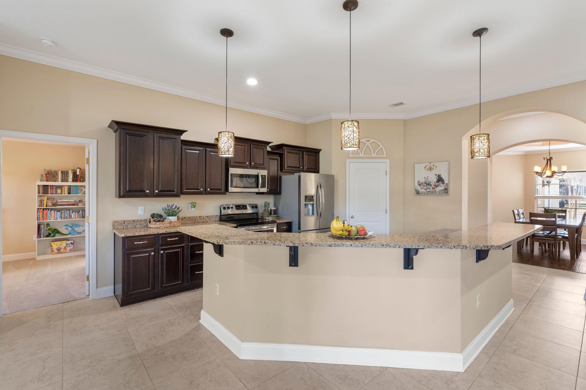 2933 Chancel Avenue Crestview, FL 32539 - Photo 9 of 44 a kitchen with stainless steel appliances granite countertop a sink a stove and a wooden floors