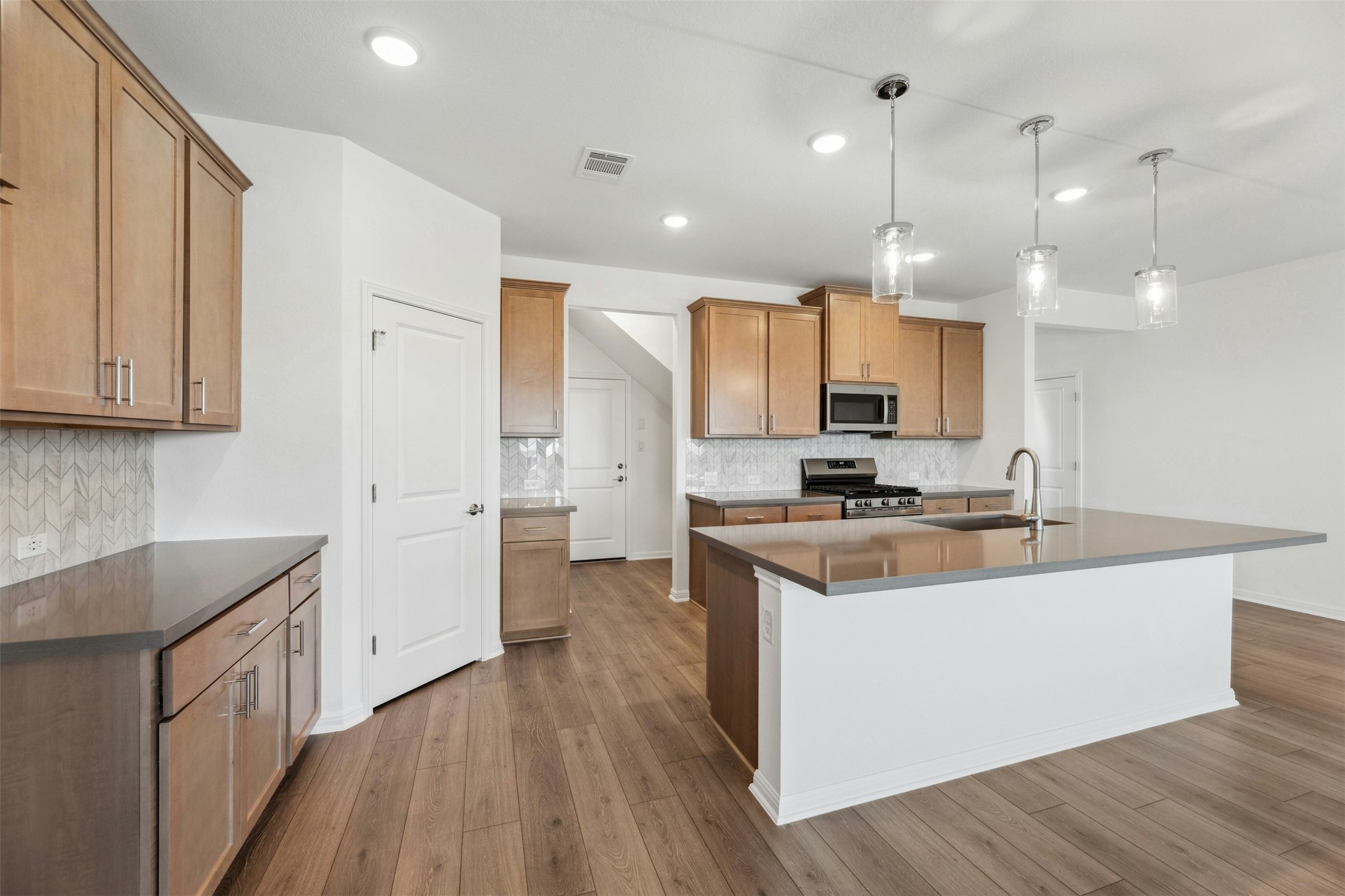 2001 Wynn Road Hutto, TX 78634 - Photo 7 of 39 A contemporary kitchen space boasts sleek countertops and an inviting island, ideal for casual dining or entertaining.