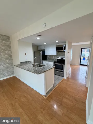 a large kitchen with stainless steel appliances granite countertop a sink and a stove