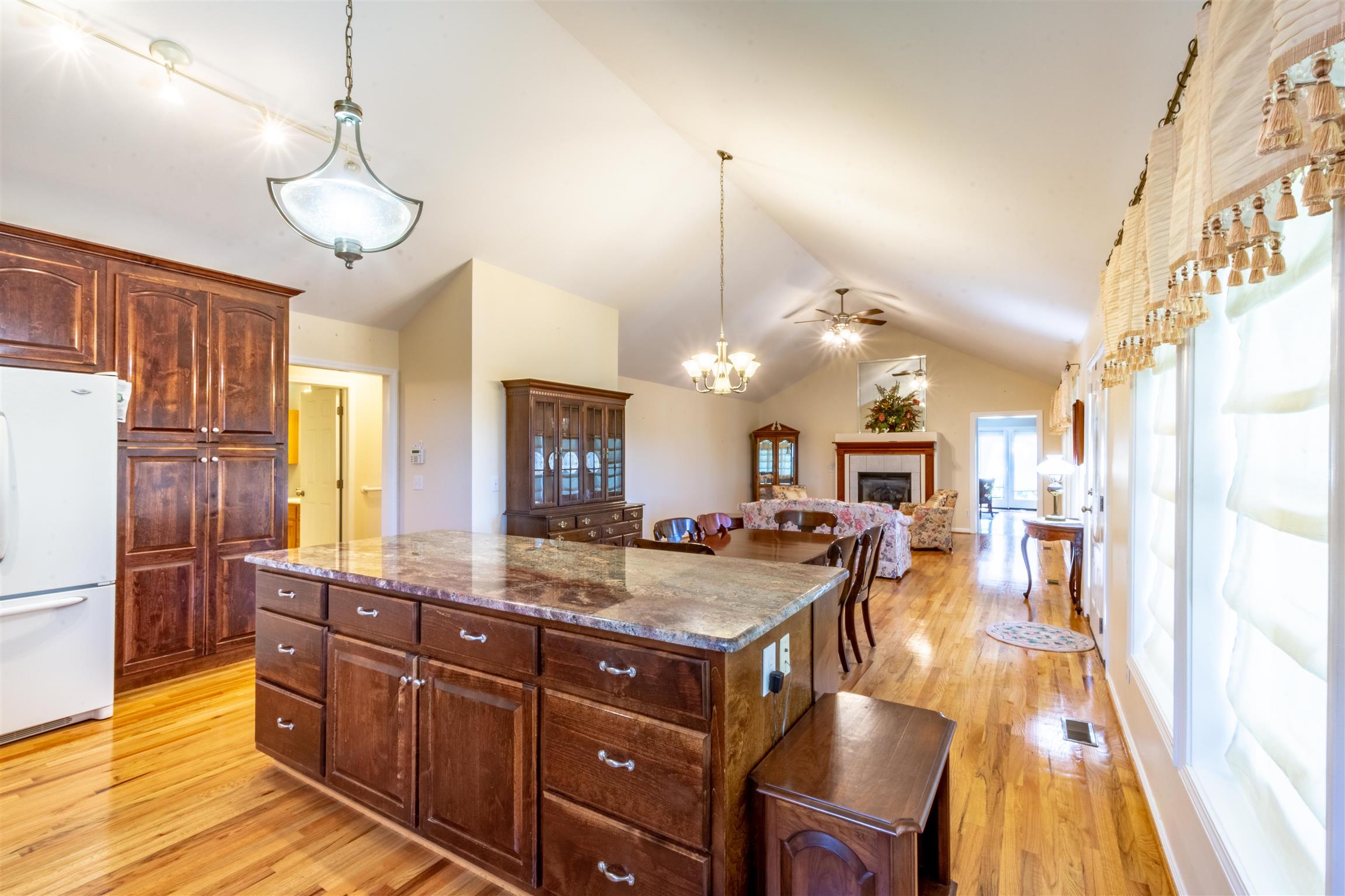 439 Agnew Road Pulaski, TN 38478 - Photo 8 of 30 a kitchen with a refrigerator a sink dishwasher and a dining table with wooden floor