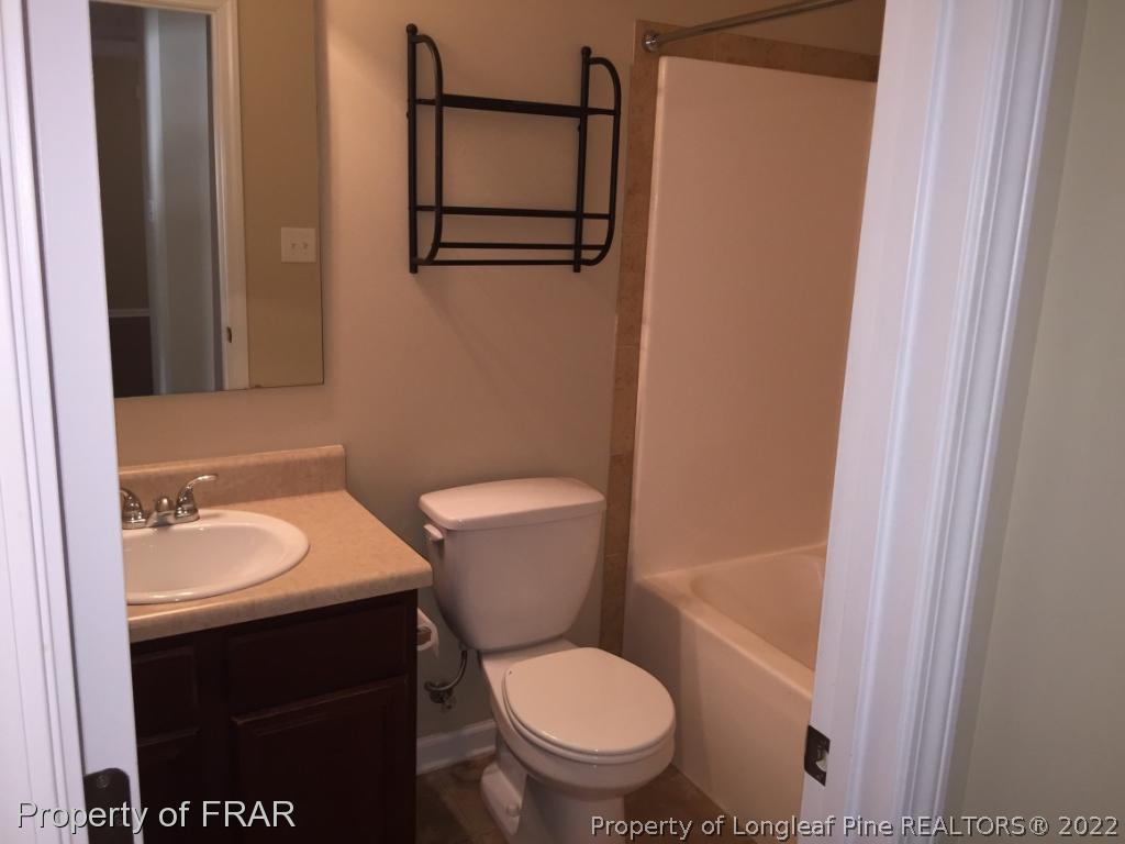 535 Cape Fear Road Raeford, NC 28376 - Photo 17 of 27 a bathroom with a granite countertop toilet sink and mirror