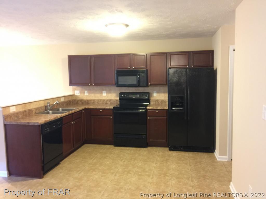 535 Cape Fear Road Raeford, NC 28376 - Photo 3 of 27 a kitchen with a refrigerator and a stove