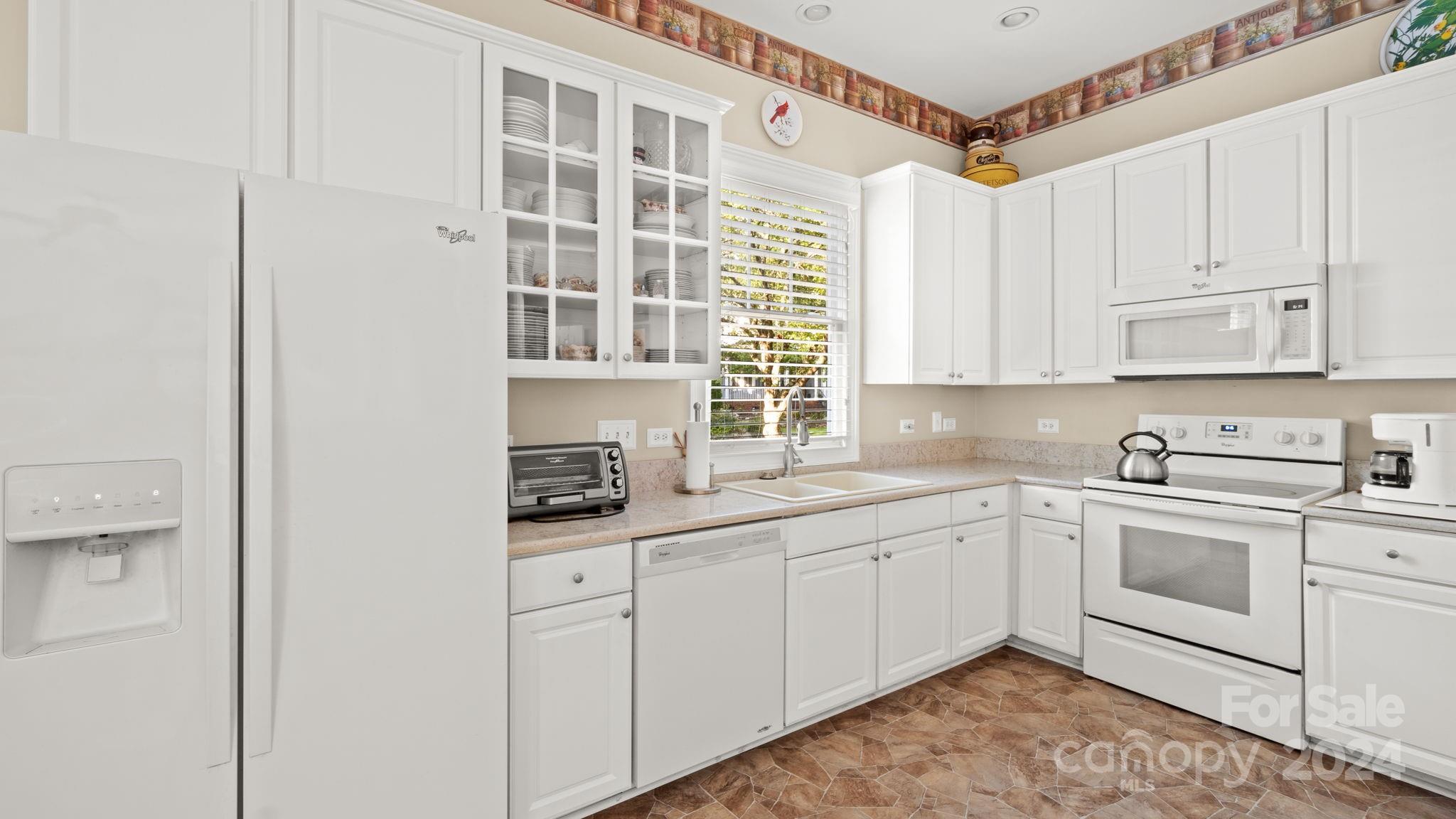 7121 Michael Scott Crossing Fort Mill, SC 29708 - Photo 16 of 46 a kitchen with stainless steel appliances granite countertop a sink and cabinets with wooden floor