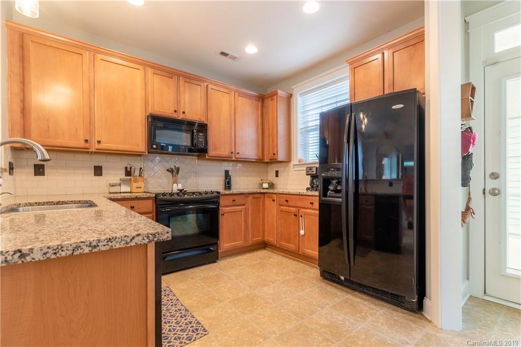 4222 Vance Road North Huntersville, NC 28078 - Photo 6 of 36 a kitchen with a refrigerator a microwave a sink and cabinets