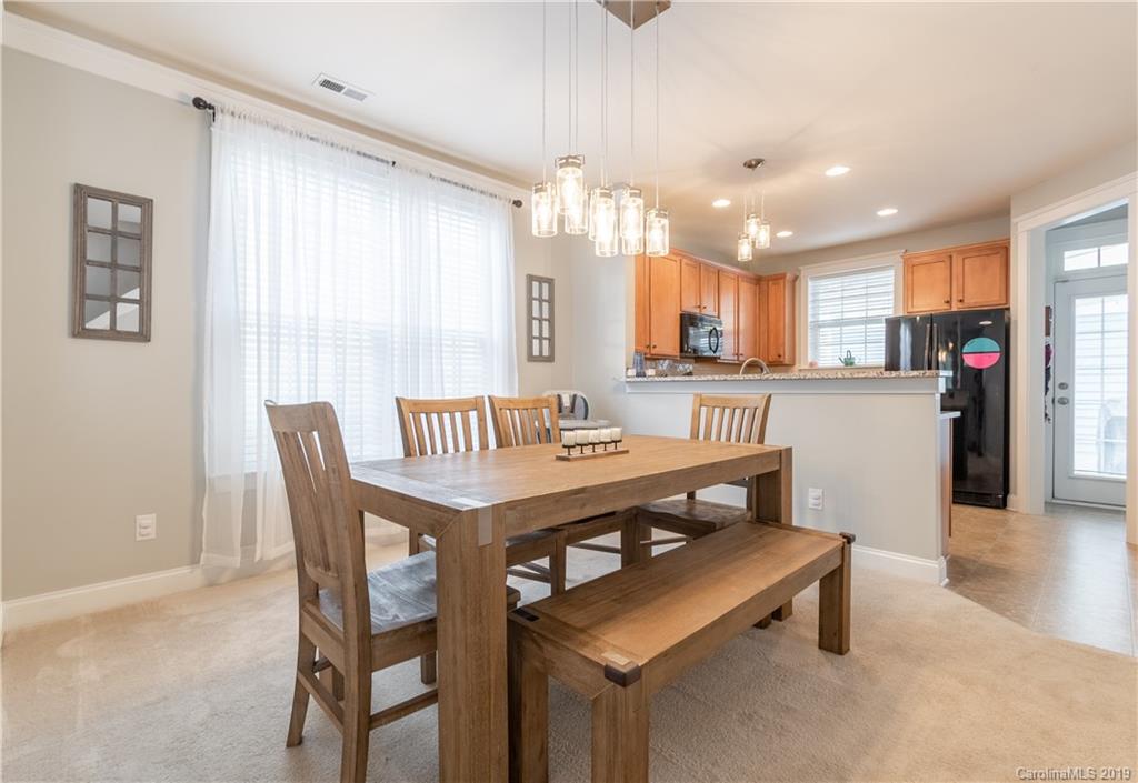 4222 Vance Road North Huntersville, NC 28078 - Photo 10 of 36 a dining room with stainless steel appliances kitchen island granite countertop a table chairs and a refrigerator