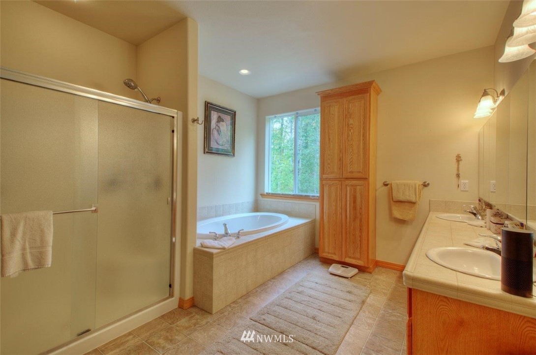 5809 Stringtown Road East Eatonville, WA 98328 - Photo 13 of 28 a bathroom with a tub sink and mirror