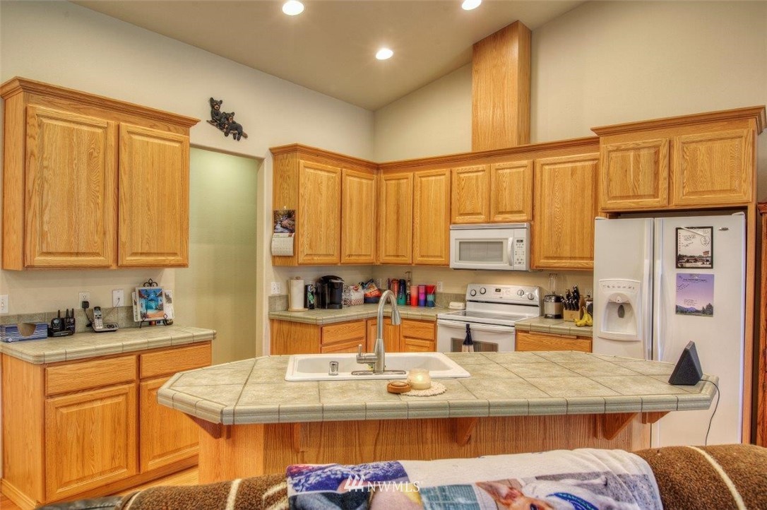 5809 Stringtown Road East Eatonville, WA 98328 - Photo 9 of 28 a kitchen with stainless steel appliances kitchen island granite countertop a sink refrigerator and cabinets