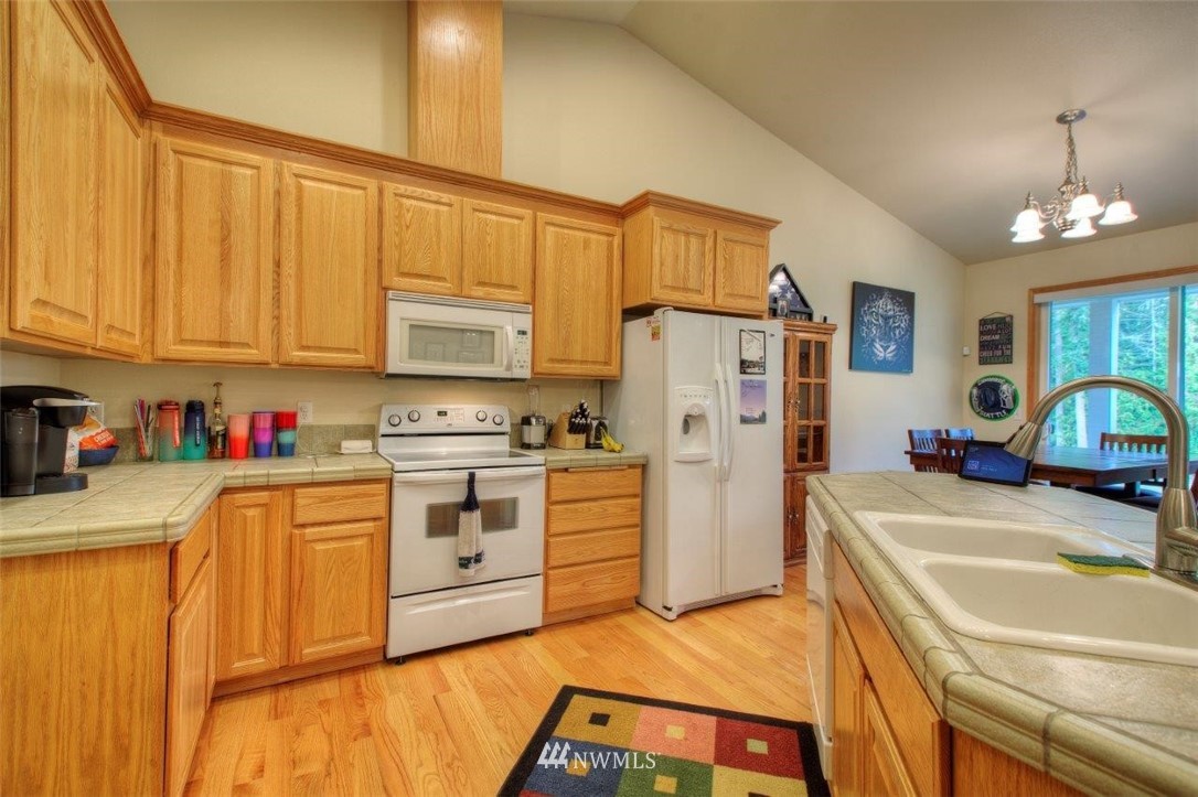 5809 Stringtown Road East Eatonville, WA 98328 - Photo 10 of 28 a kitchen with stainless steel appliances a refrigerator sink and cabinets