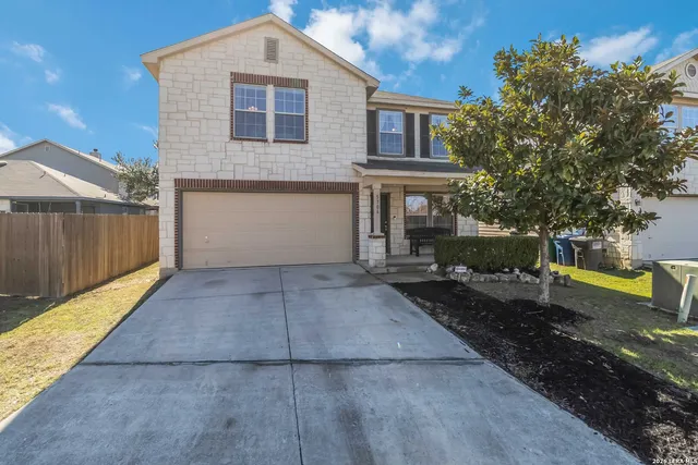 a front view of a house with a yard and a garage