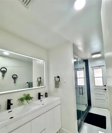 a bathroom with a sink a mirror and a shower