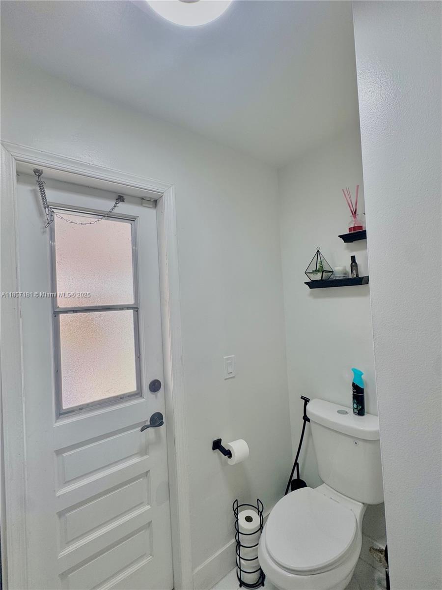 15421 Southwest 158th Street Miami, FL 33187 - Photo 11 of 31 a white toilet sitting next to a bathroom sink