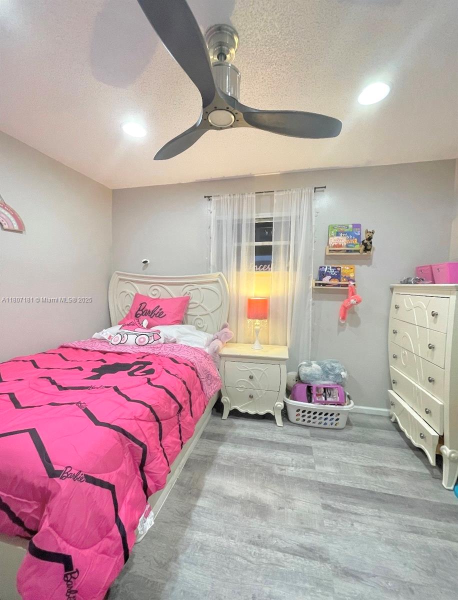 15421 Southwest 158th Street Miami, FL 33187 - Photo 18 of 31 a bedroom with a bed and chandelier