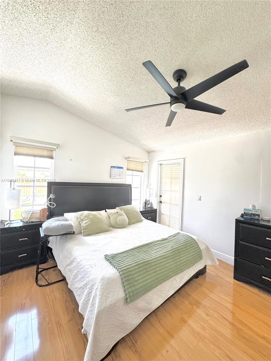 15421 Southwest 158th Street Miami, FL 33187 - Photo 21 of 31 a bedroom with a bed ceiling fan and a large window
