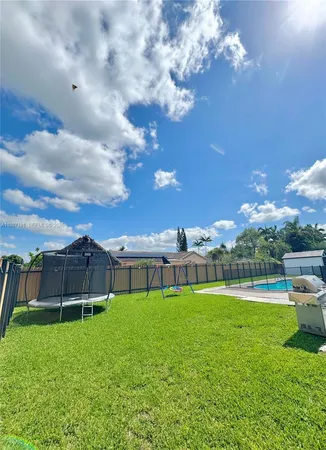 a view of yard with swimming pool and green space