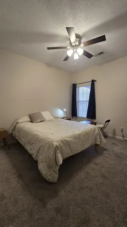 a bedroom with a bed and a ceiling fan