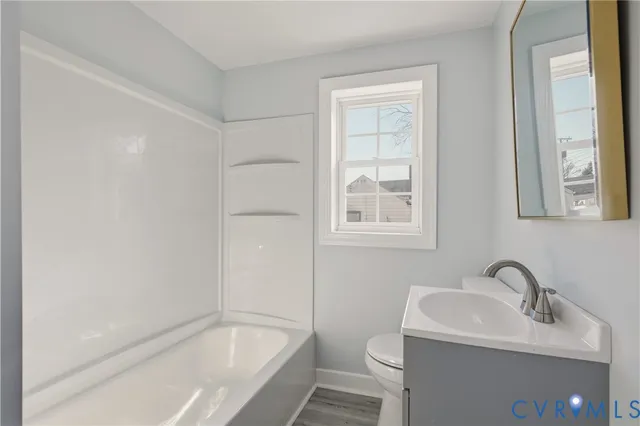 a white bath tub sitting next to a white sink and a toilet