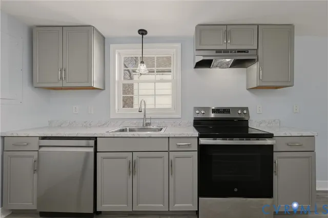 a kitchen with cabinets appliances a sink and a counter top space