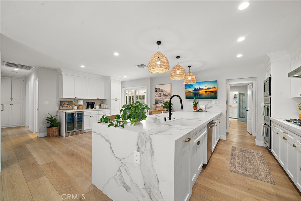 8741 La Roca Avenue Fountain Valley, CA 92708 - Photo 15 of 50 Beautifully remodeled kitchen has quartz countertops with waterfall, custom cabinetry, stainless appliances, breakfast bar