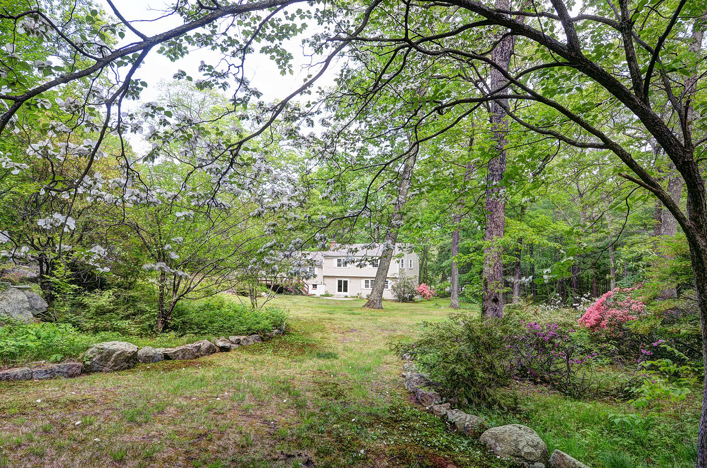 154 South Bald Hill Road New Canaan, CT 06840 - Photo 18 of 21 a backyard of a house with lots of green space and a fountain