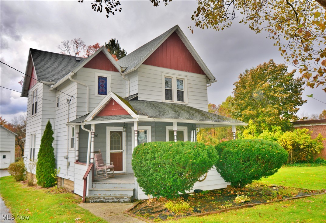 6696 Madison Road Thompson, OH 44086 - Photo 1 of 24 View of front of property featuring a porch, roof with shingles, a front yard, and a detached garage