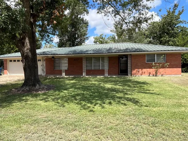 a front view of house with yard and trees