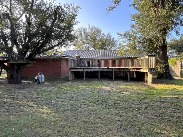 a view of a house with a backyard and a tree