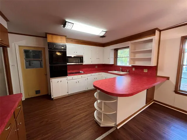 a room with furniture pool table wooden floor and windows