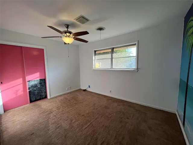 a view of a livingroom with a ceiling fan and window
