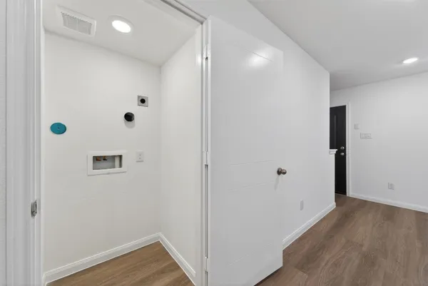 a view of a hallway with wooden floor