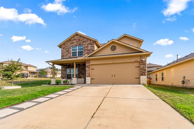 a front view of a house with a yard and garage