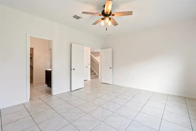 an empty room with closet and a chandelier fan