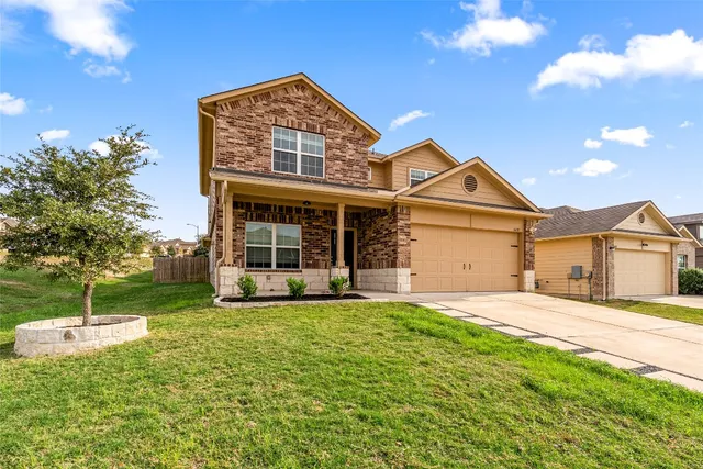 a front view of a house with a yard and garage