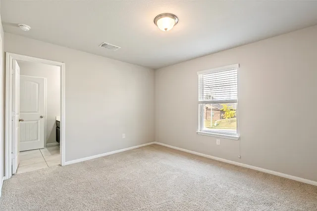 an empty room with windows and a bathroom