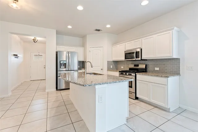 a kitchen with stainless steel appliances granite countertop a refrigerator and a sink