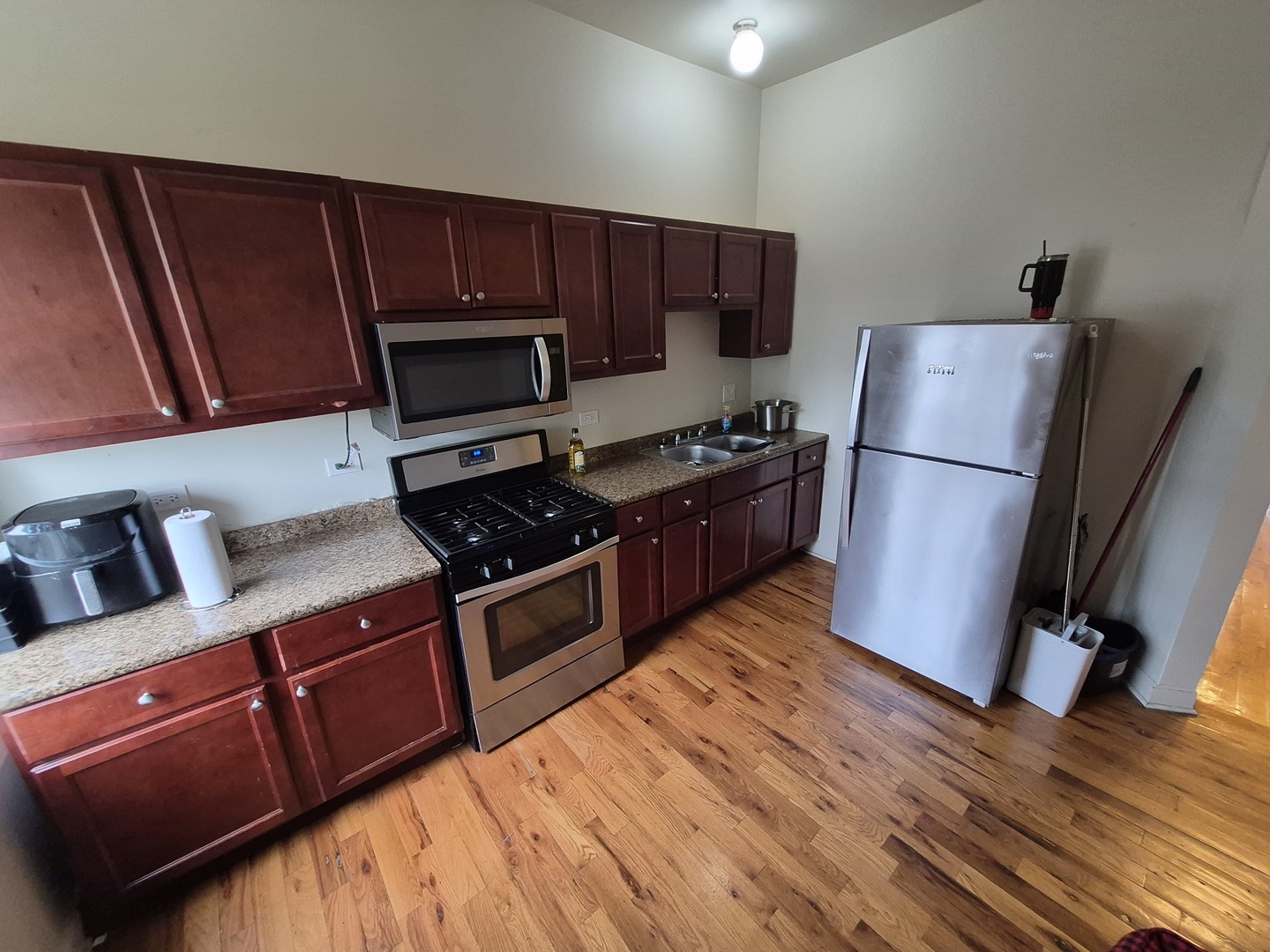 4126 West Adams Street Chicago, IL 60624 - Photo 3 of 19 a kitchen with wooden floors and wooden cabinets