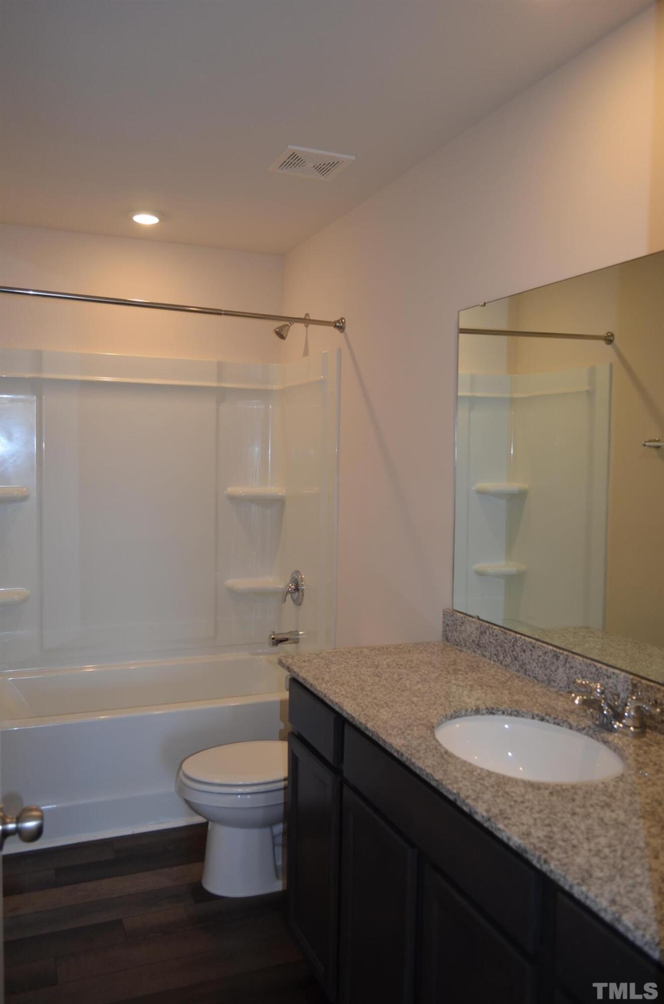 3537 Pinnacle Peak Drive Raleigh, NC 27604 - Photo 30 of 41 a bathroom with a granite countertop sink toilet a mirror and shower