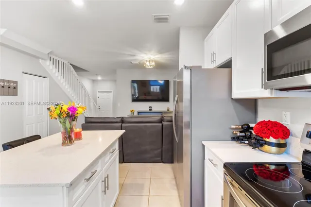 a kitchen with a sink white cabinets and stainless steel appliances