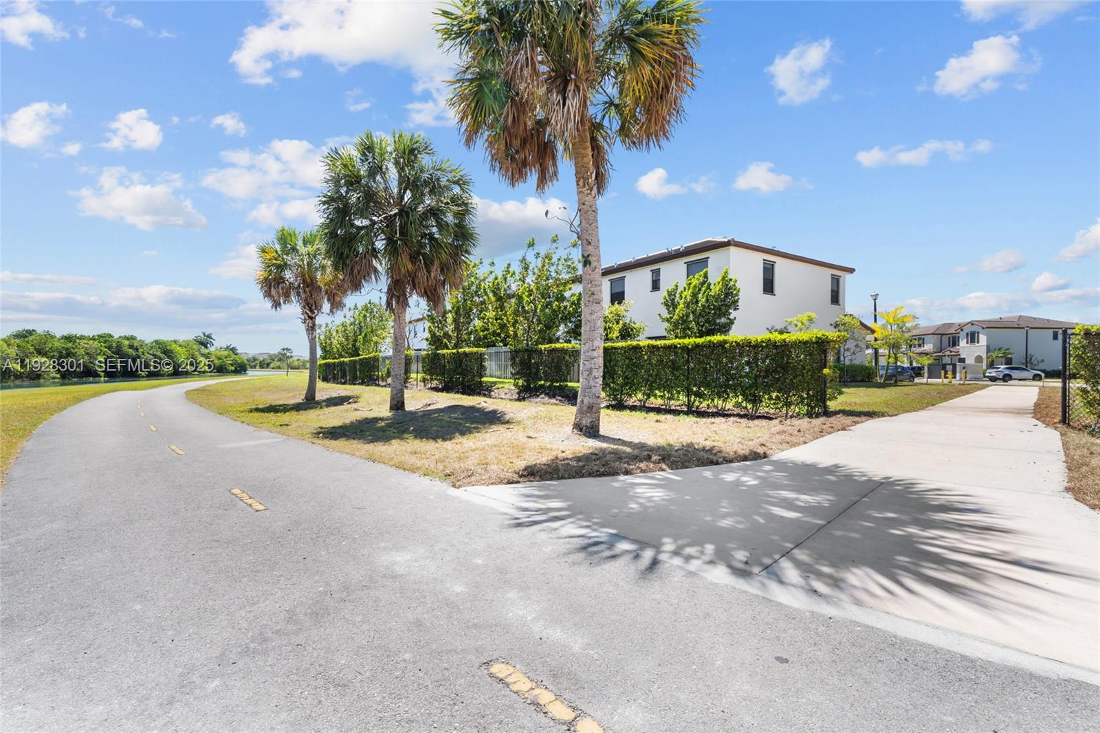 9917 Southwest 228th Terrace Miami, FL 33190 - Photo 6 of 36 a view of a street with a building in the background