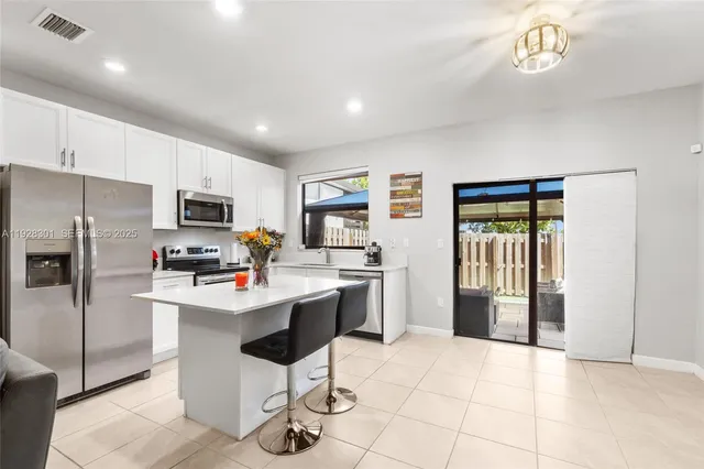 a kitchen with stainless steel appliances a refrigerator sink and microwave