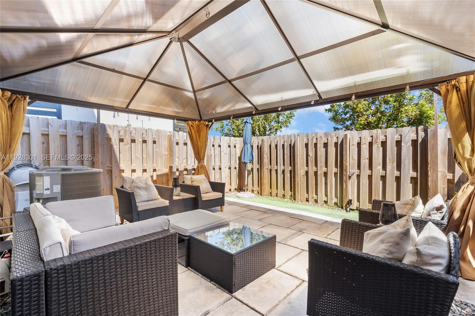 9917 Southwest 228th Terrace Miami, FL 33190 - Photo 10 of 36 a outdoor living space with furniture and umbrella