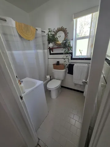 a bathroom with a sink toilet and window
