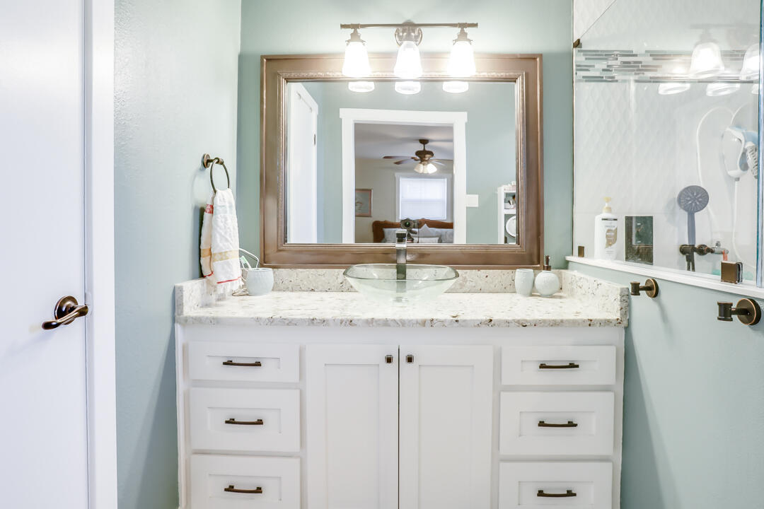 4306 57th Street Lubbock, TX 79413 - Photo 23 of 23 a bathroom with a granite countertop sink and a mirror