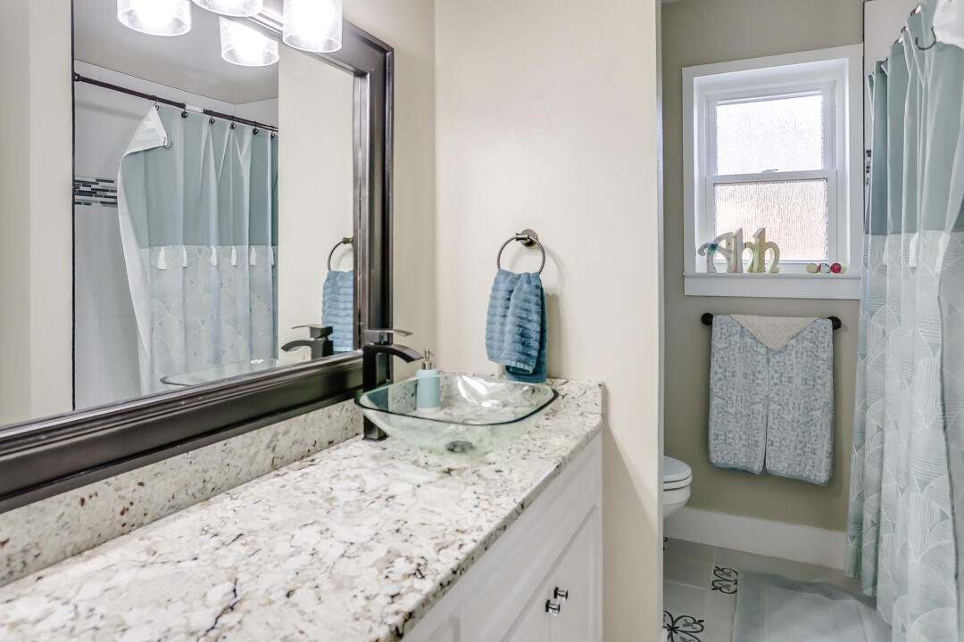4306 57th Street Lubbock, TX 79413 - Photo 6 of 23 a bathroom with a granite countertop sink and a mirror