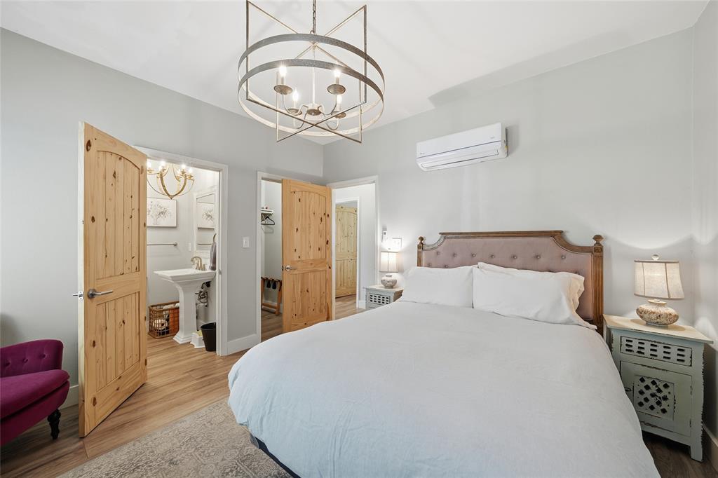 708 South 9th Street Waco, TX 76706 - Photo 17 of 26 a bedroom with a large bed and a chandelier