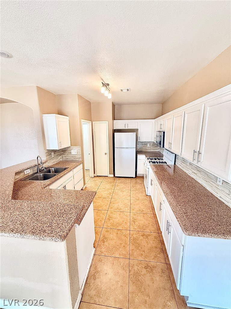 4313 Ranch Foreman Road North Las Vegas, NV 89032 - Photo 7 of 27 Generous counter space and classic cabinetry define this functional, tile-floored culinary workspace.