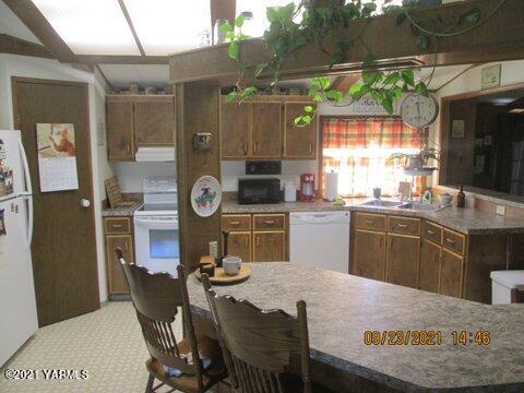 861 Hinman Road Harrah, WA 98933 - Photo 6 of 23 a kitchen with stainless steel appliances granite countertop a sink a stove a refrigerator a dining table and chairs