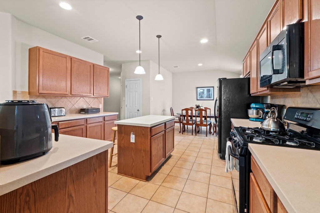 12008 Lansdowne Road Austin, TX 78754 - Photo 12 of 29 A well-appointed kitchen features a central island, gas range, and ample cabinetry for culinary pursuits.