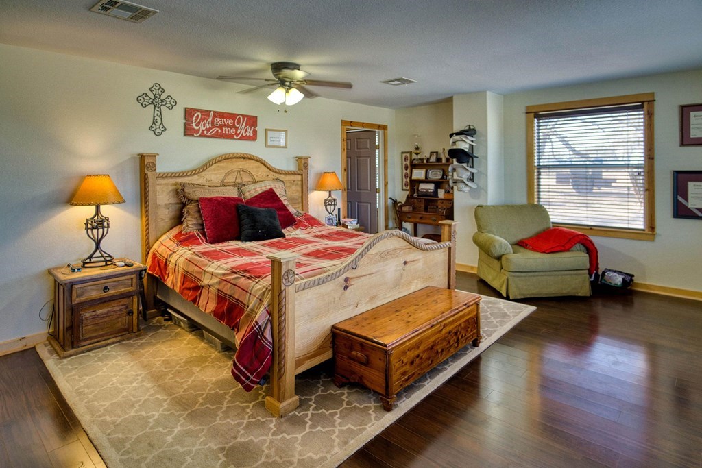 6446 Blackjack Road Fredonia, TX 76842 - Photo 18 of 48 a bedroom with a bed and wooden floor