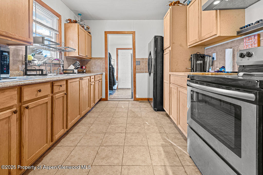 604 Tucker Street Craig, CO 81625 - Photo 13 of 35 a kitchen with stainless steel appliances granite countertop a refrigerator and a stove top oven