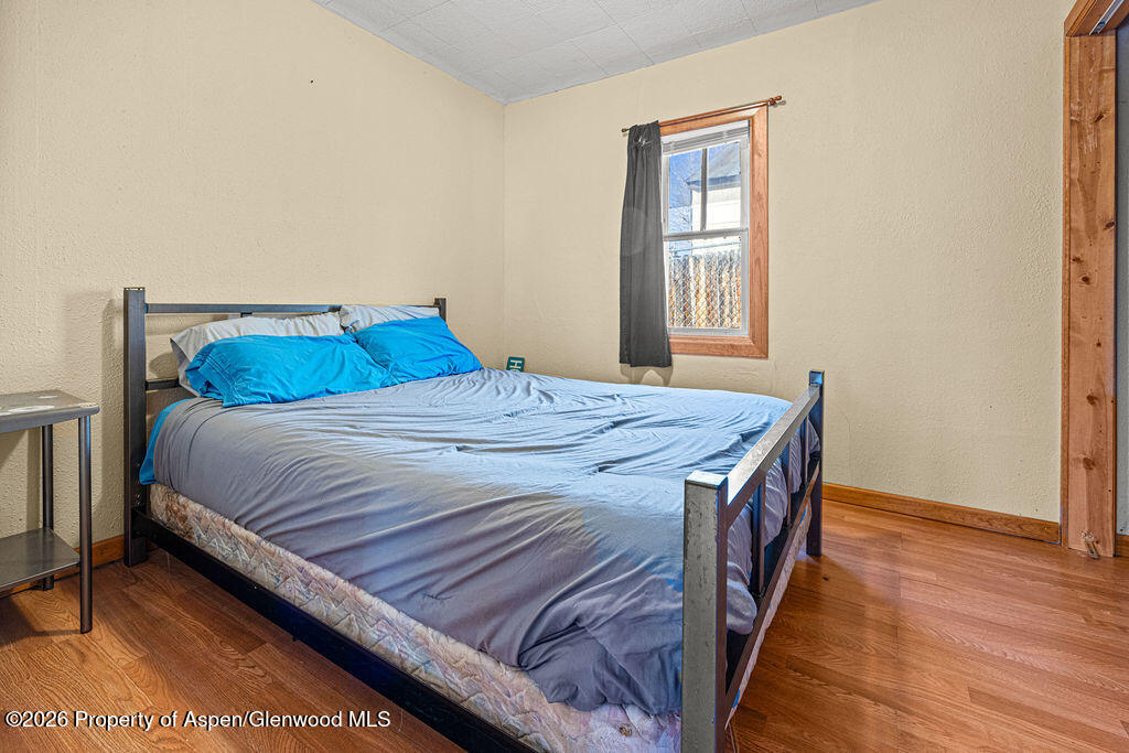 604 Tucker Street Craig, CO 81625 - Photo 15 of 35 a bedroom with a bed and wooden floor